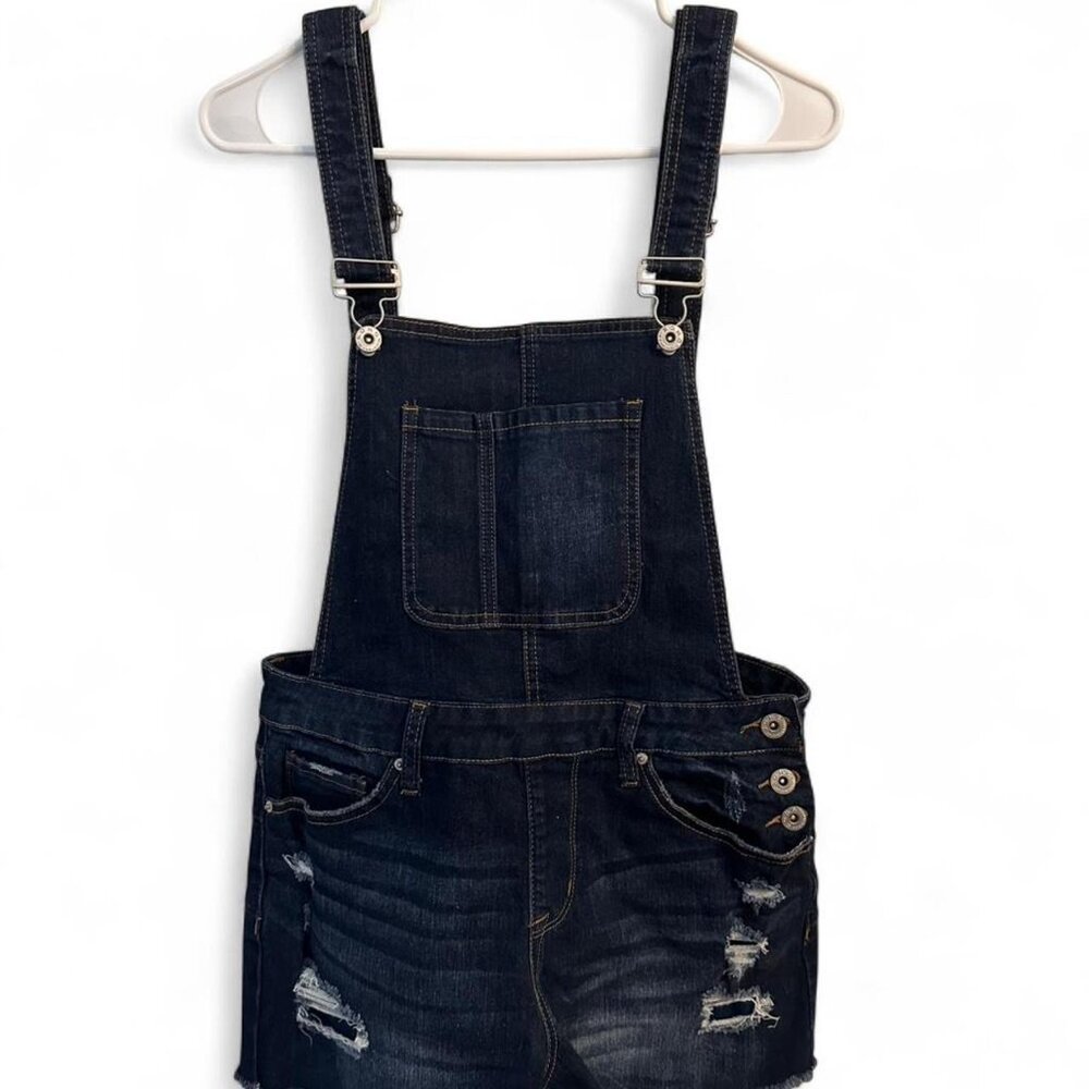 Navy denim overall shorts with distressed details and Curvy Shortall branding.